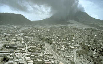 Soufriere Hills volcano in the background with the ash-covered city of Plymouth (former capital of Montserrat) in the foreground.